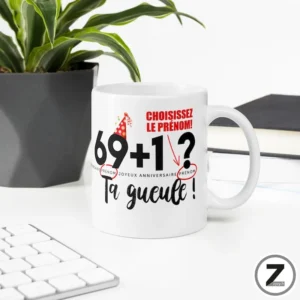 Mug personnalisable 69+1 TA GUEULE ! présenté sur un bureau avec le motif visible