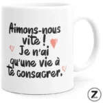 White mug with black handwritten French quote about loving quickly, small pink hearts accent the text.