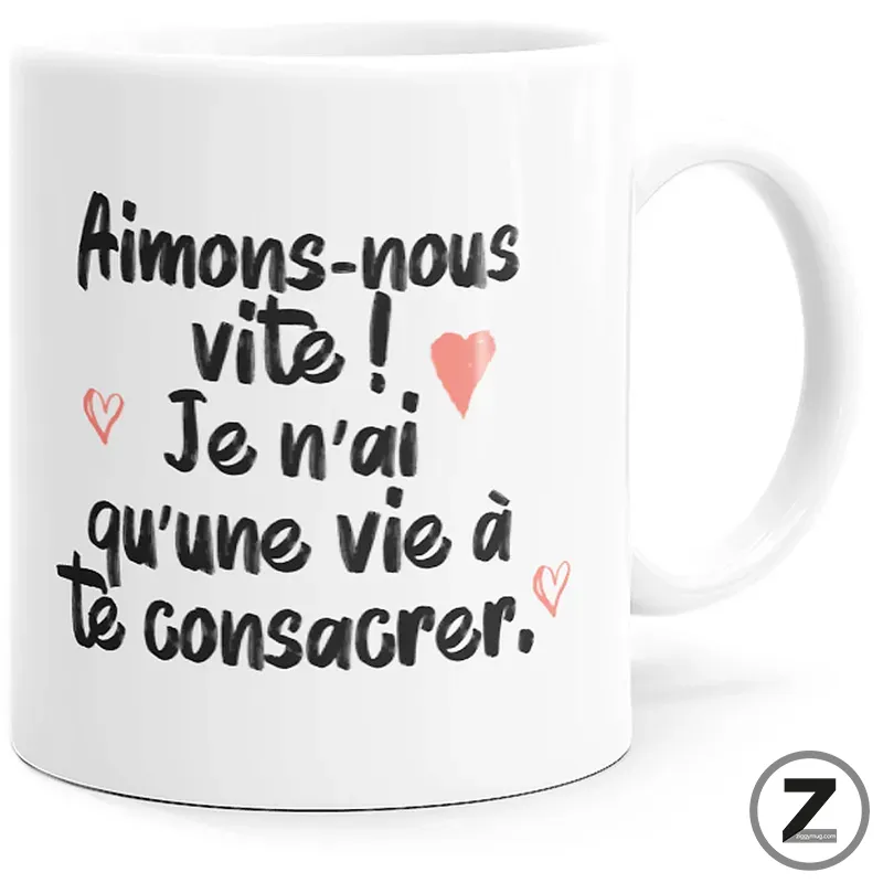 White mug with black handwritten French quote about loving quickly, small pink hearts accent the text.