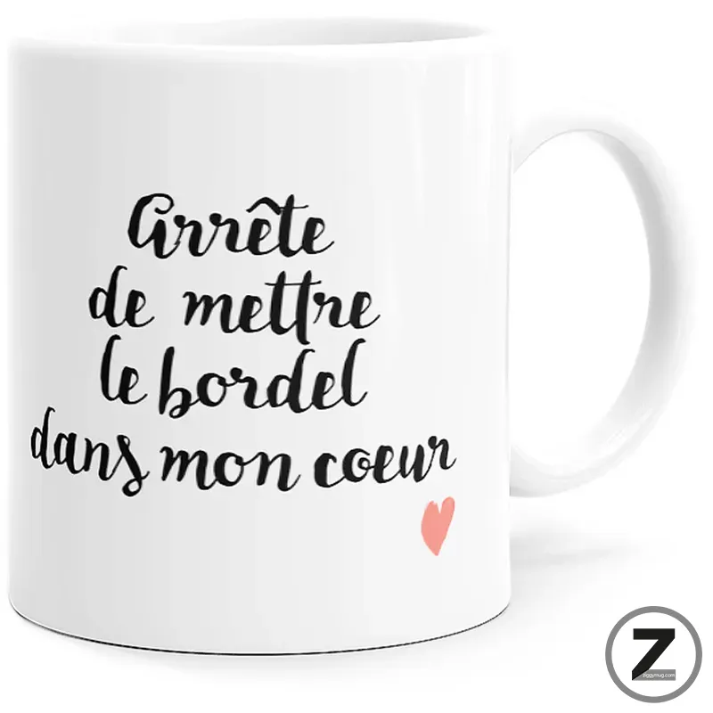 White ceramic mug with black cursive French text 'Arrête de mettre le bordel dans mon cœur' and a small pink heart.