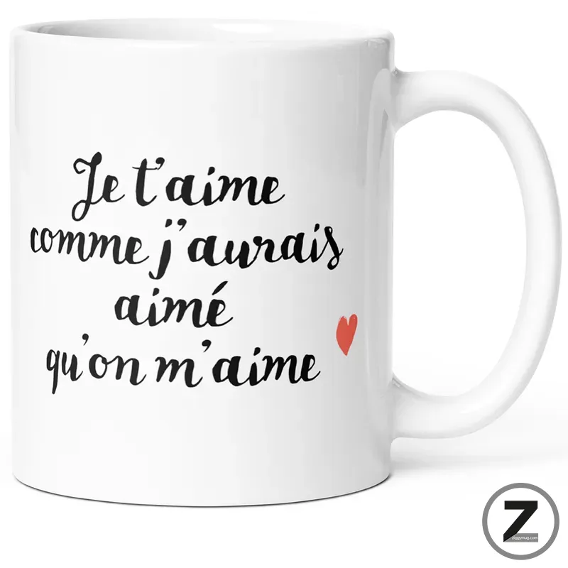 White ceramic mug with a French romantic quote: “Je t'aime comme j'aurais aimé qu'on m'aime” and a small red heart on the side of the mug.
