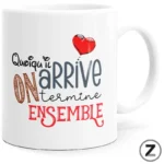 White ceramic mug with a playful typography design that reads 'On arrive ensemble' in mixed fonts and a red heart accent.