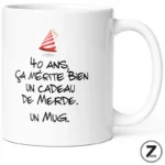 White ceramic mug with a red party-hat graphic and a bold French birthday joke: '40 ans, ça mérite bien un cadeau de merde. Un mug.'