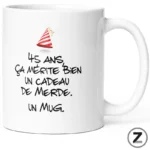 White mug with a small party hat and the French joke text: '45 ans ça mérite bien un cadeau de merde. un mug.'