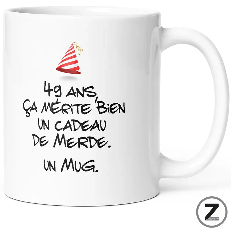 White ceramic mug with a humorous French birthday caption and a small party hat graphic: '49 ans ça mérite bien un cadeau de merde. un mug'