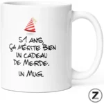 White mug with a small red party hat and a bold French joke: '51 ans, ça mérite bien un cadeau de merde. Un mug'.