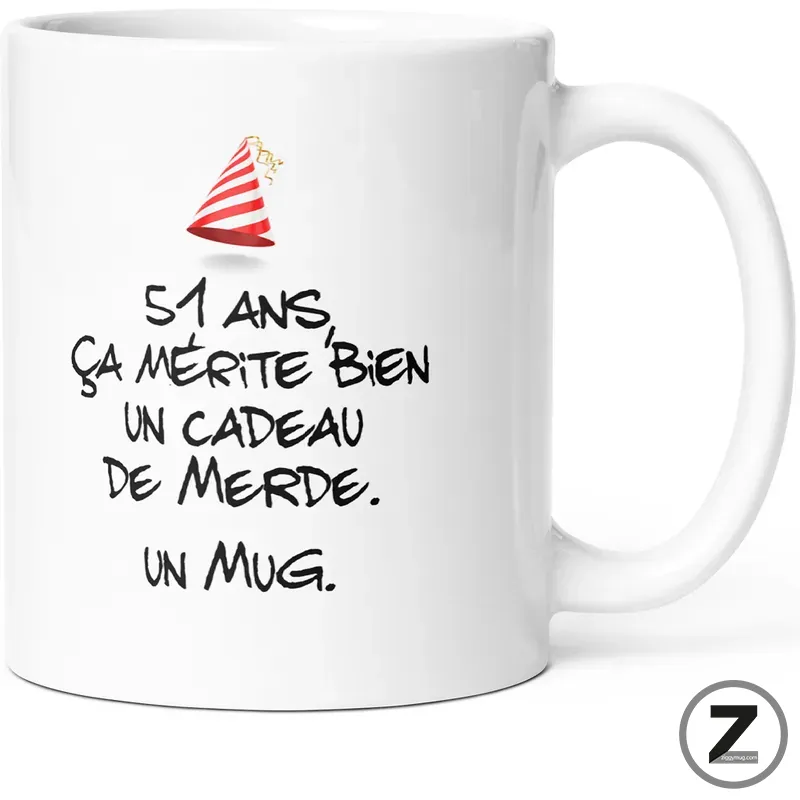White mug with a small red party hat and a bold French joke: '51 ans, ça mérite bien un cadeau de merde. Un mug'.