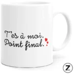 White ceramic mug featuring black cursive French text “T’es à moi. Point final.” with small red hearts on the right.