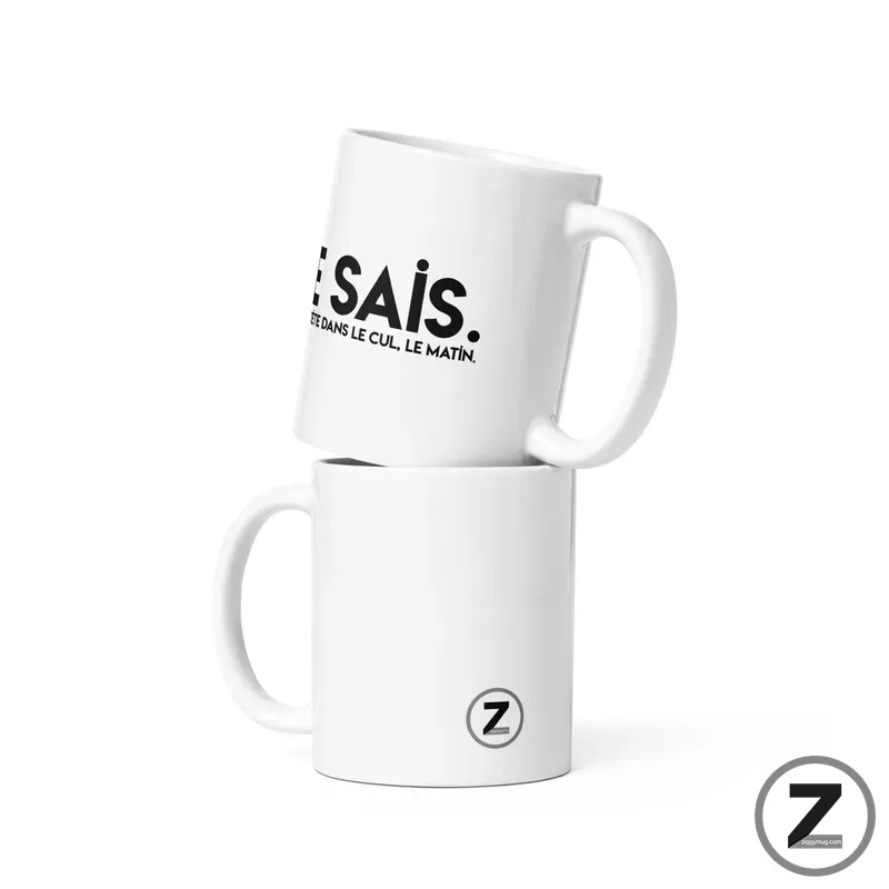 Two white ceramic mugs stacked, one tilted on top of the other, with bold black text on the upper mug and a small Z logo on the bottom mug.