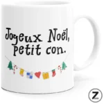 White ceramic mug showing the French Christmas message 'Joyeux Noël, petit con.' with a small decorative garland under the text to the left.