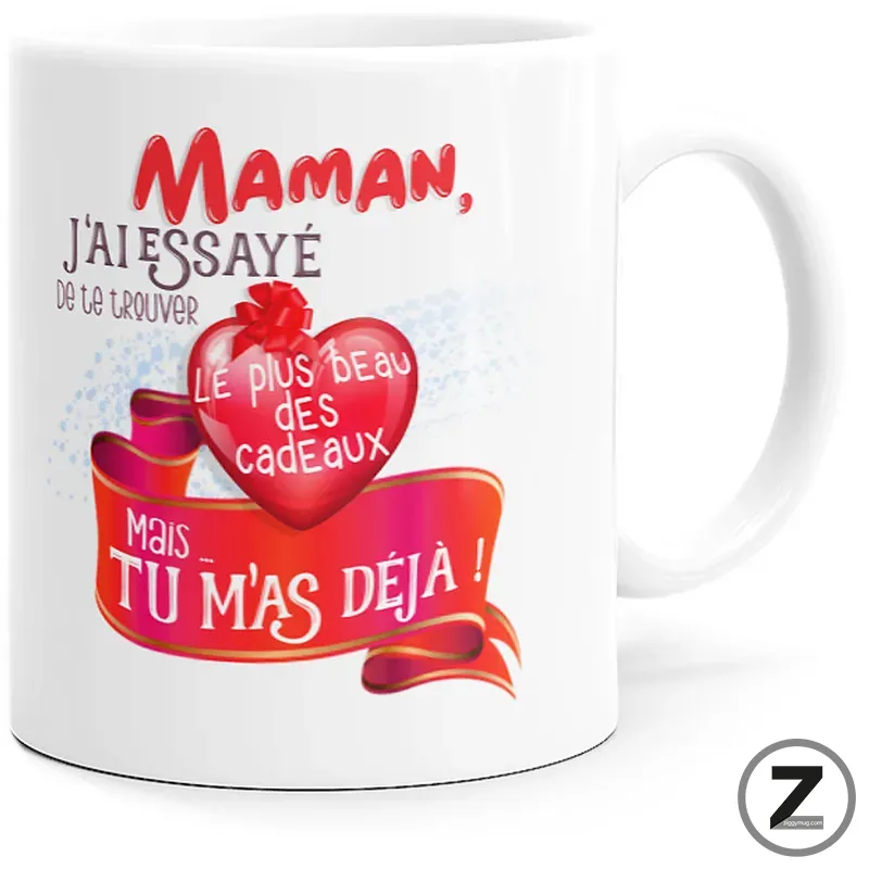 White mug featuring a red heart and pink ribbon with a French message for Mom: 'Maman, j'ai essayé de te trouver le plus beau des cadeaux mais tu m'as déjà!'