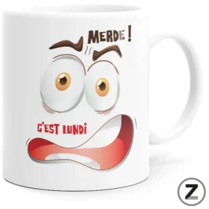 White mug featuring a shocked cartoon face with bulging eyes and a wide red mouth, plus the French text 'Merde! C'est lundi' for a Monday mood joke.