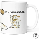 White mug featuring a cartoon dog making a middle-finger gesture with the caption 'Mon chien m'adore.'