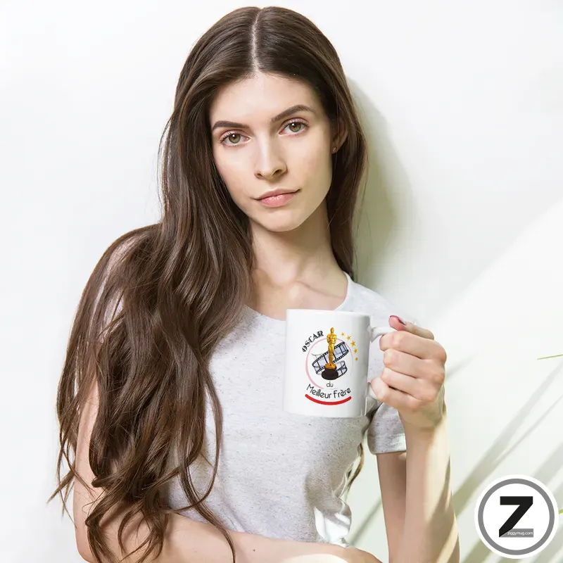 Woman with long brown hair in a light gray top, holding a white mug with a trophy illustration.