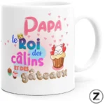 White mug with colorful French greeting: 'Papa le Roi des câlins et des gâteaux' with hearts, cupcakes, and a cat cupcake illustration.