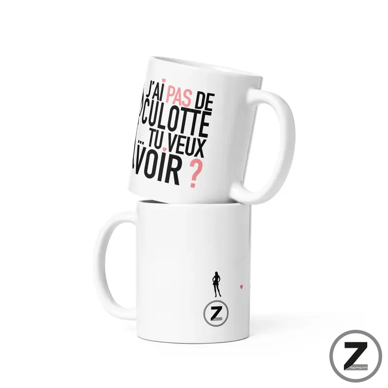 Two white mugs stacked together; the top mug features bold black and pink French text, with the bottom mug showing a small figure and a Z logo.
