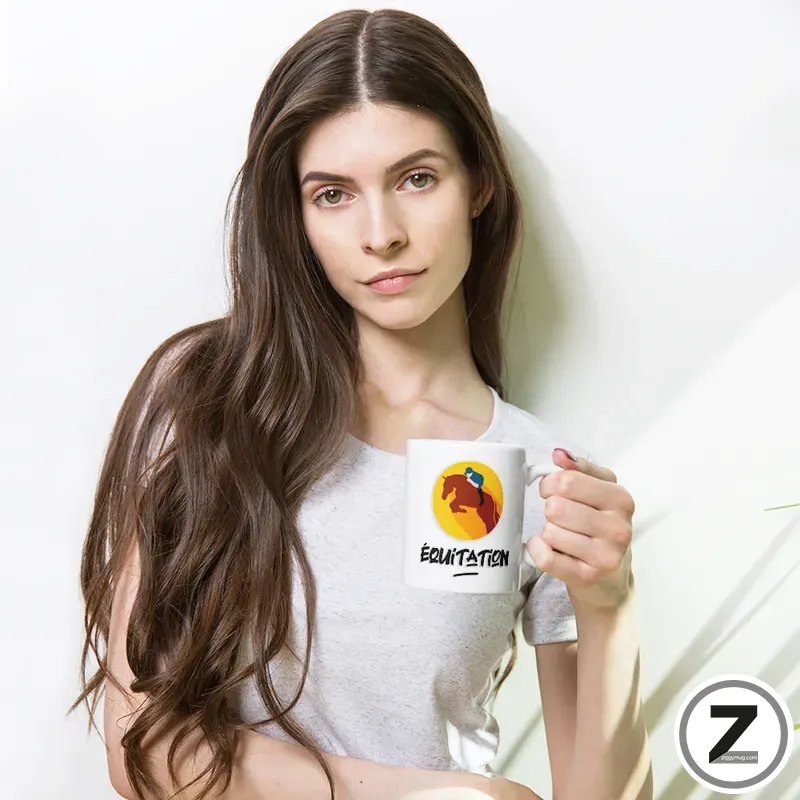 Young woman with long brown hair holds a white mug featuring a yellow circle logo with a horse rider and the word ÉQUITATION.