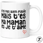White ceramic mug featuring a bold black French phrase: t’es pas bien foutée mais t’es ma maman et je t’aime, with a small red heart.