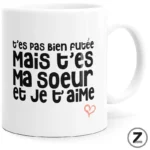 White mug featuring bold French text: “t'es pas bien foutée / Mais c'est ma soeur / et je t'aime” with a small pink heart doodle.