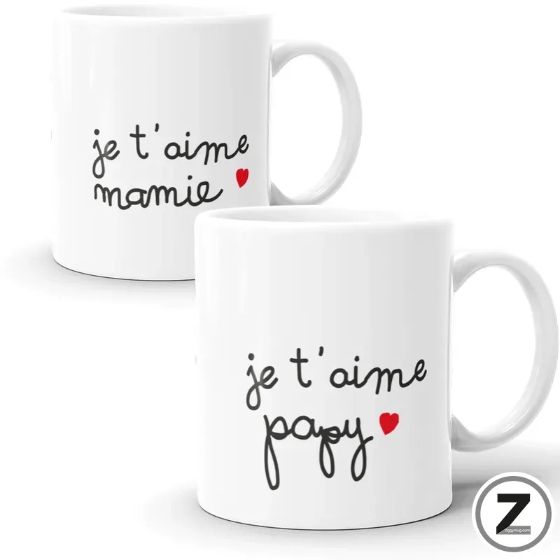 Two white mugs with handwritten French phrases 'je t'aime maman' and a small red heart; and 'je t'aime papa' on the other mug, set against a white background.